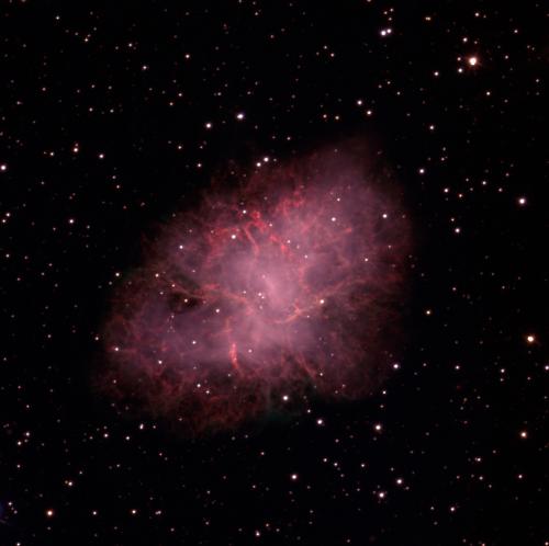 An elongated oval shaped cloud is in the image middle, on a slight diagonal angle from bottom left to top right. The background is black with a few small dots of white stars scattered throughout. The cloud is red in colour, darker at the edges and becoming lighter with hints of white in the middle.