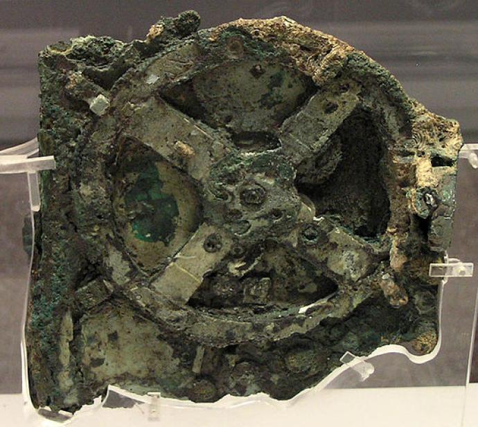 Photograph of the Antikythera mechanism, an ancient corroded device with visible gears and mechanisms, believed to be an early form of an astronomical calculator